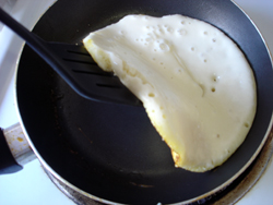 Flipping a pancake in a frying pan.