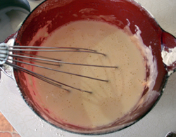 Pancake batter and whisk in a mixing bowl.