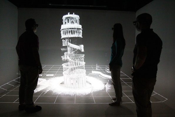 Three people looking at a 3D map of the Leaning Tower of Pisa.