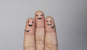 three fingers with faces painted on them.