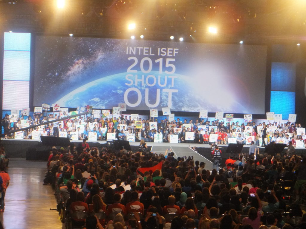 A big crowd in front of a stage. Banners say Intel ISEF 2015 Shout Out.