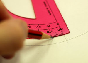 Someoen is marking an eight degree angle with a protractor.