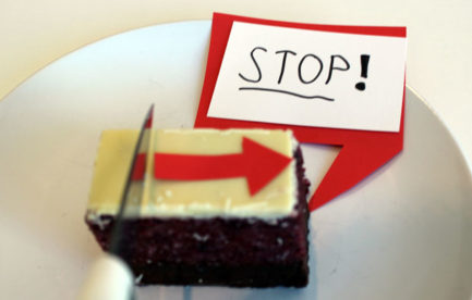 A knife is movine along a rectangular cake. There is a speech bubble saying 'stop'
