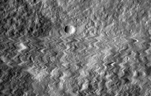 A wiggly photo of a cratered surface.