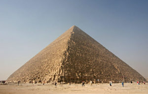 Image of a pyramid with tiny people in the foreground.