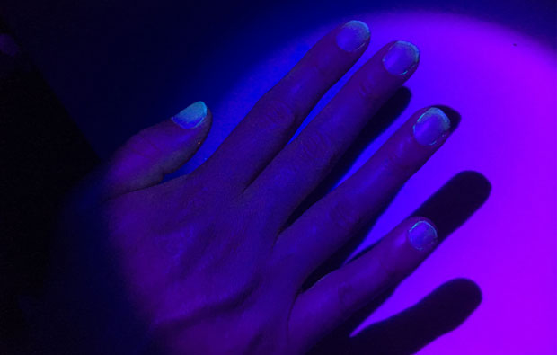 Image of a hand under purple light.