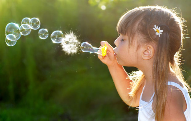 Photo of a little girl blowing bubbles.