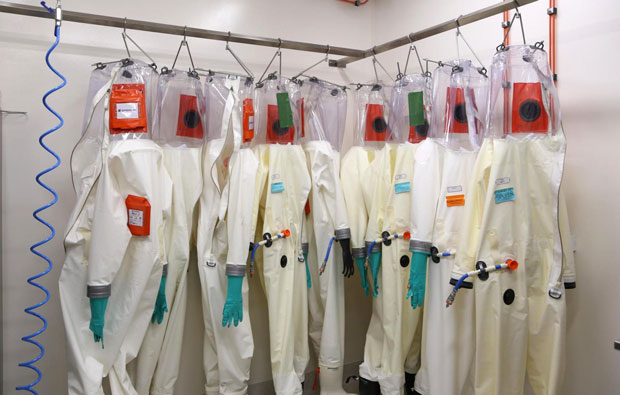 several biohazard suits hanging from a rack
