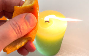 Squeezing orange peel near a lit candle