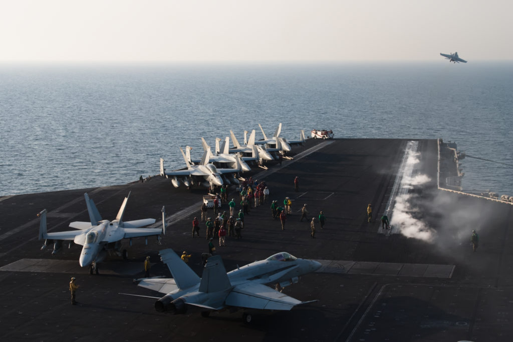 Aircraft lined up on an aircraft carrier deck.