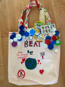 Callico bag decorated with bottle lids and recycled items.