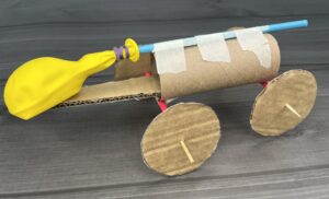A balloon car made from cardboard, skewers and straws.